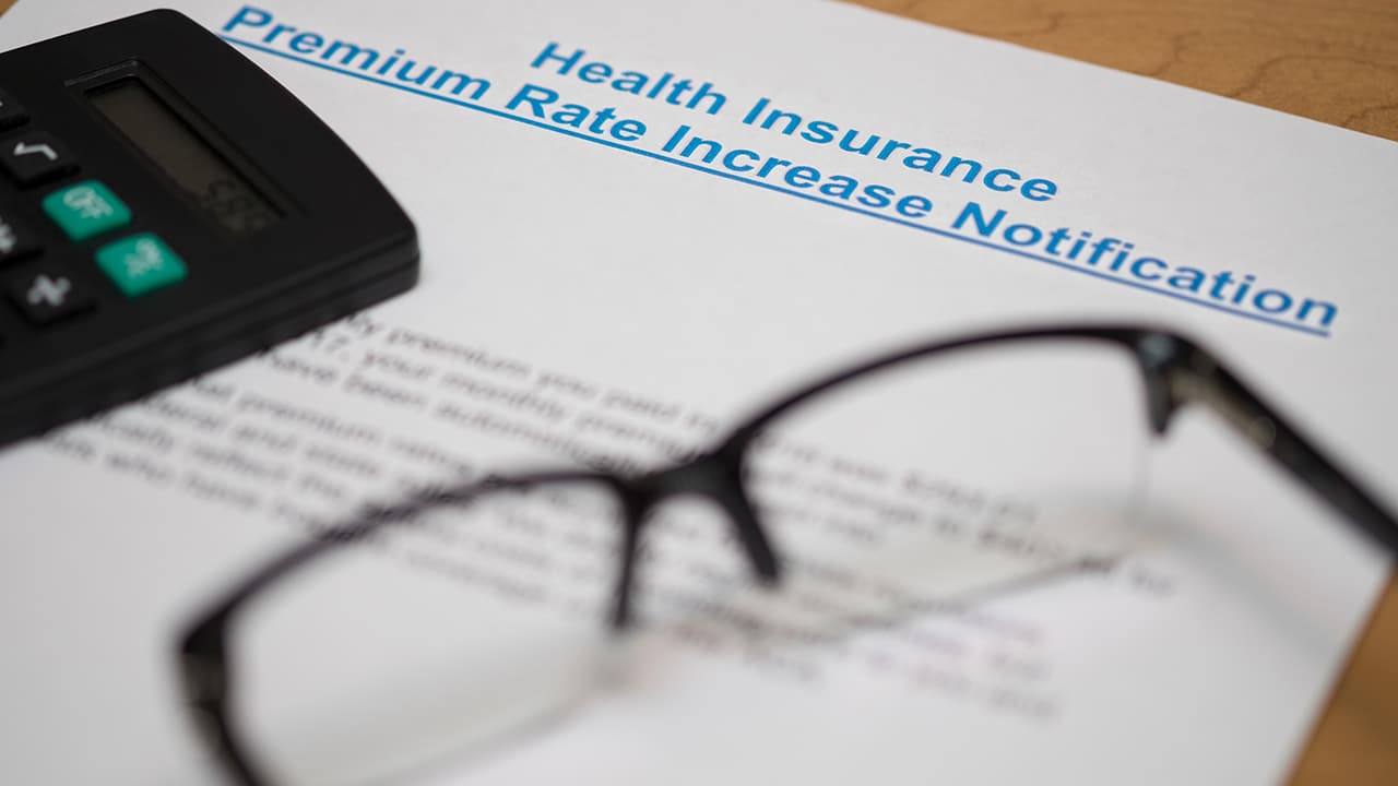 NOTICE OF INCREASING IN PREMIUM RATE OF HEALTH INSURANCE WITH A PAIR OF GLASSES AND A CALCULATOR