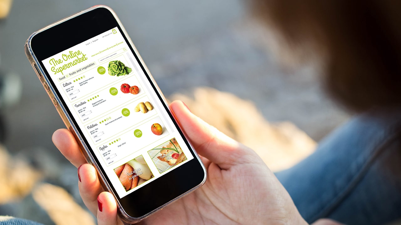 close-up view of young woman shopping groceries on online supermarket with her mobile phone.