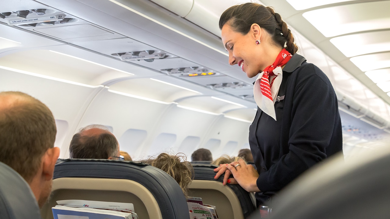 flight attendant offering passenger something to drink