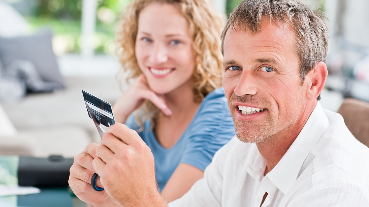 Man cutting up his credit card at home