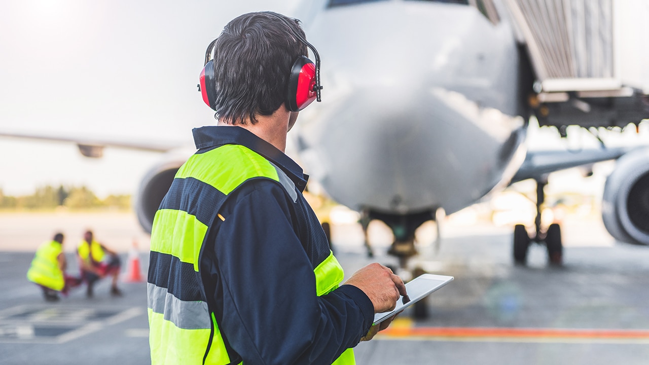 Male worker controlling aircraft and writing information
