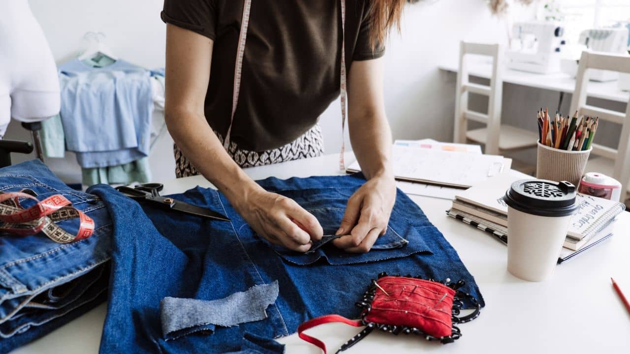 image of a woman sewing with denim material