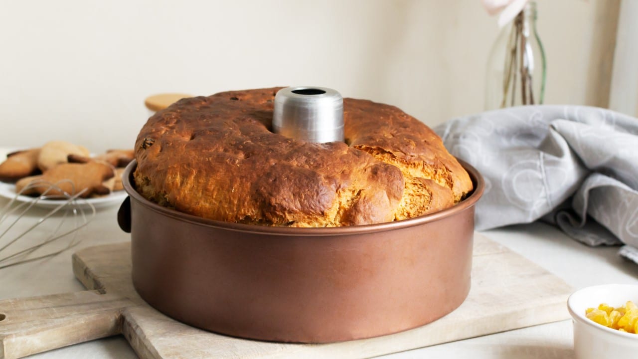 Pie in an aluminum mold on a wooden cutting board in the kitchen