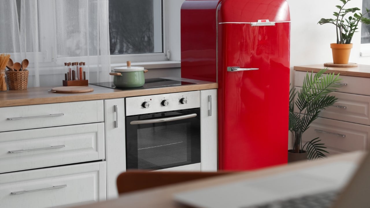 Interior of modern kitchen with red fridge and oven