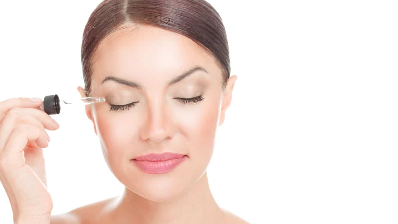 Woman applying serum cosmetics