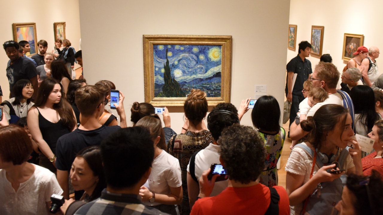 Crowd of people near the Starry Night by Vincent van Gogh painting in Museum of Modern Art in New York City