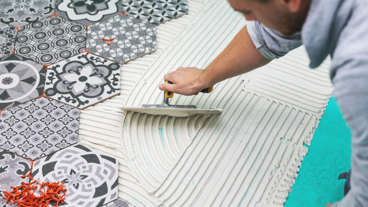 Man laying down flooring in home