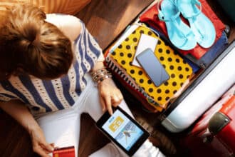 Woman with suitcase packed booking holiday