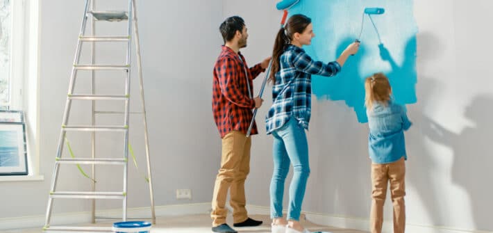 Family painting walls with a bright blue paint