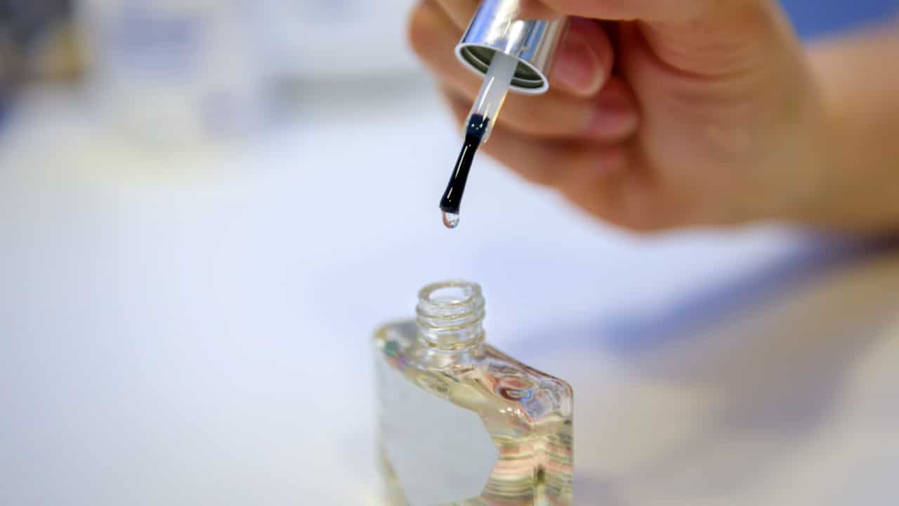 Female hand holding clear fingernail Polish