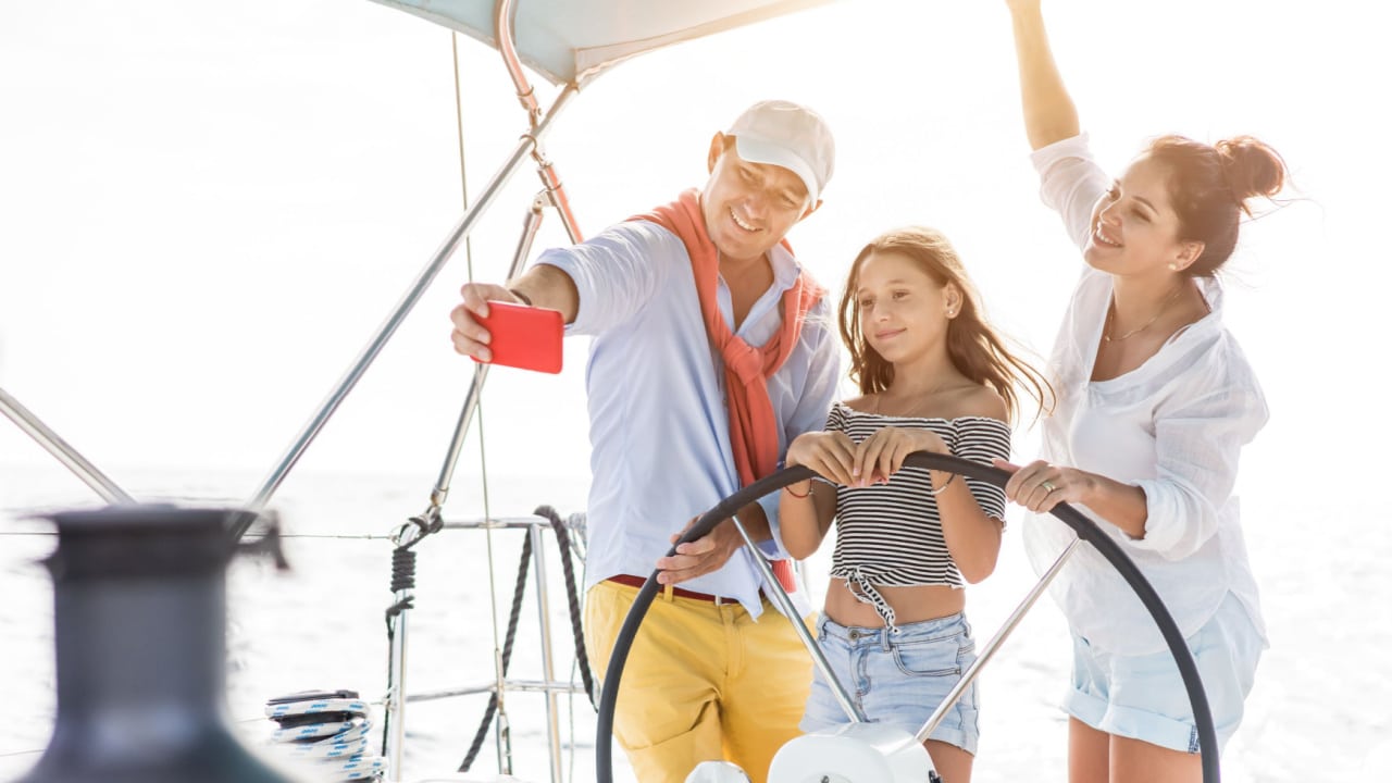 a man, woman and young girl taking a selfie on a luxury boat