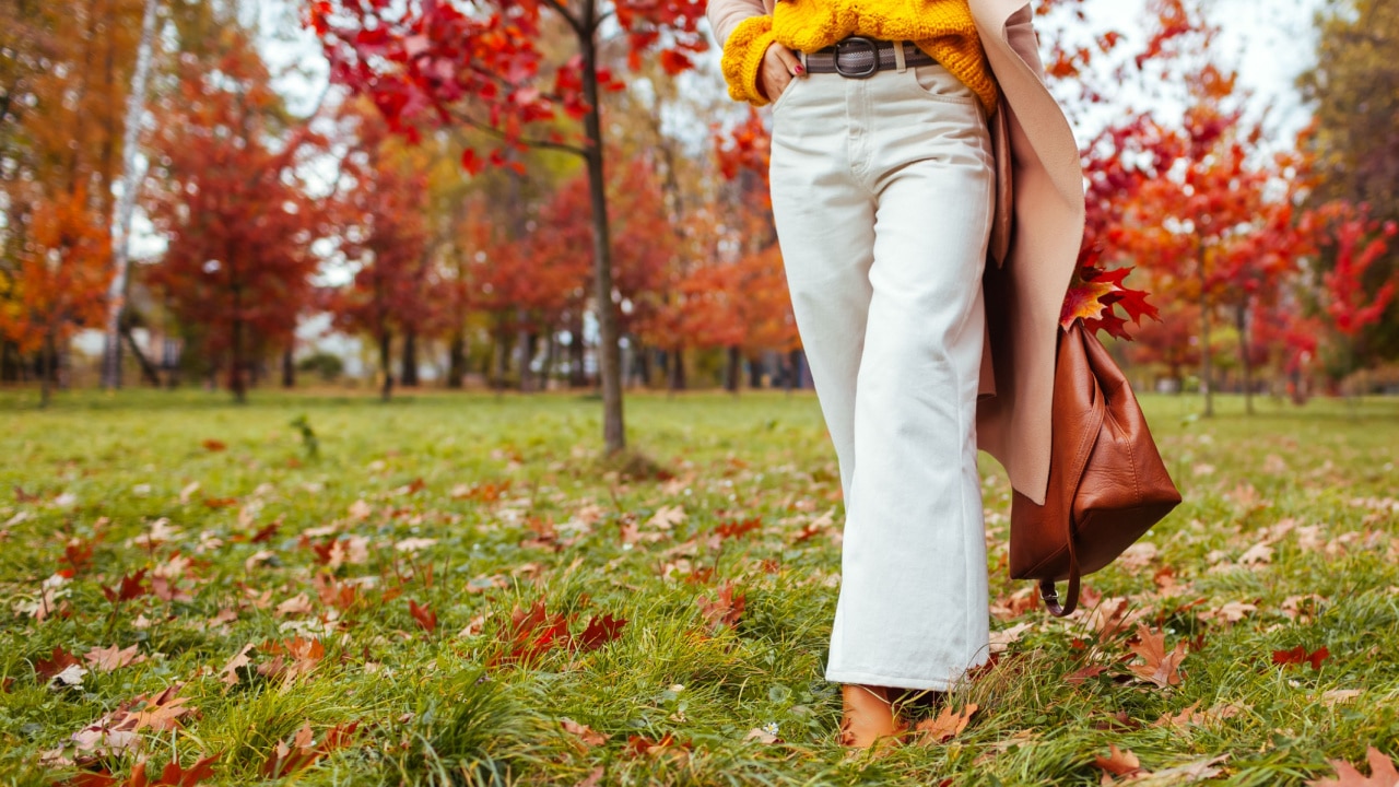 Woman wearing classic and chic clothing while taking a walk outside in nature