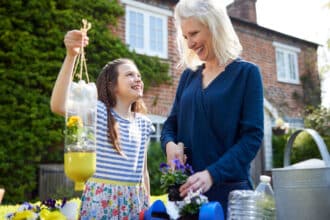 young girl and a woman repurposing household items to use in the garden