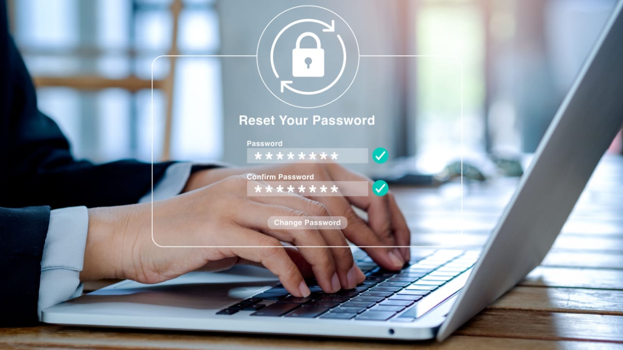 man typing on a laptop with a closed padlock and reset your password message