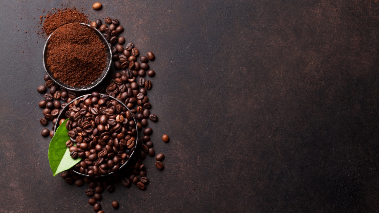 Coffee beans and ground powder on stone