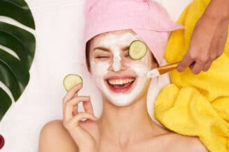 Laughing woman with cosmetic face mask on