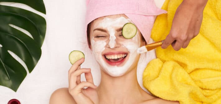 Laughing woman with cosmetic face mask on