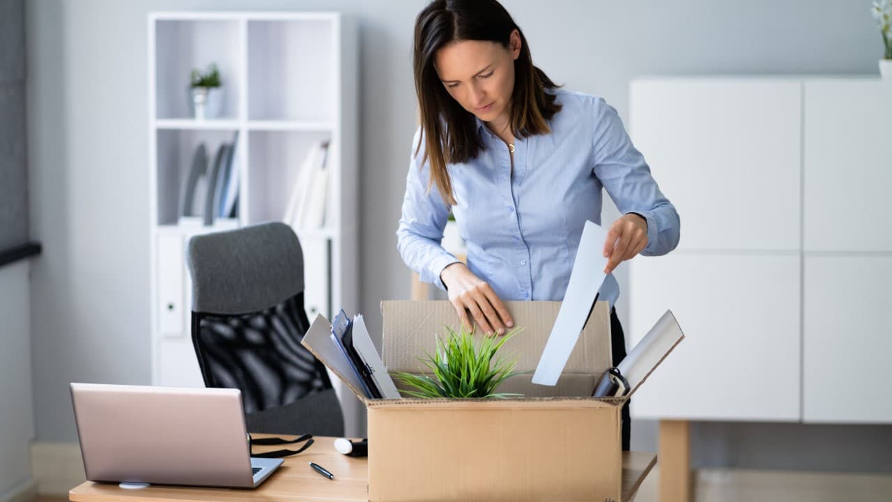 Woman resigning from job, packing workplace items