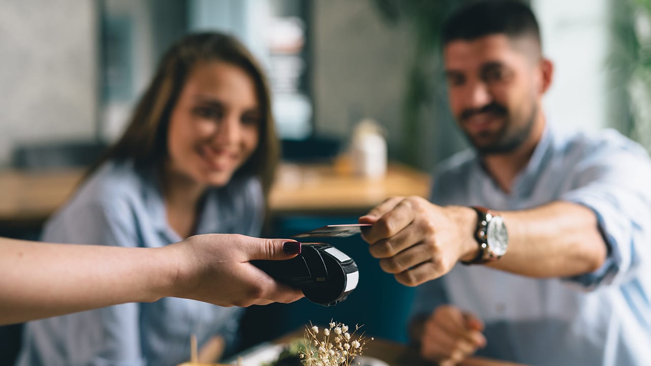 man making payment with smartphone in restaurant