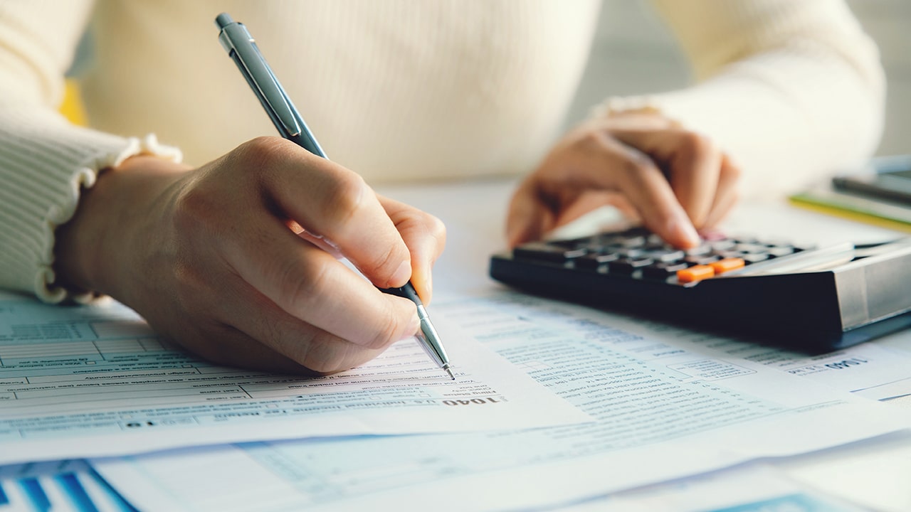 Closeup woman filling form of Individual Income Tax Return,