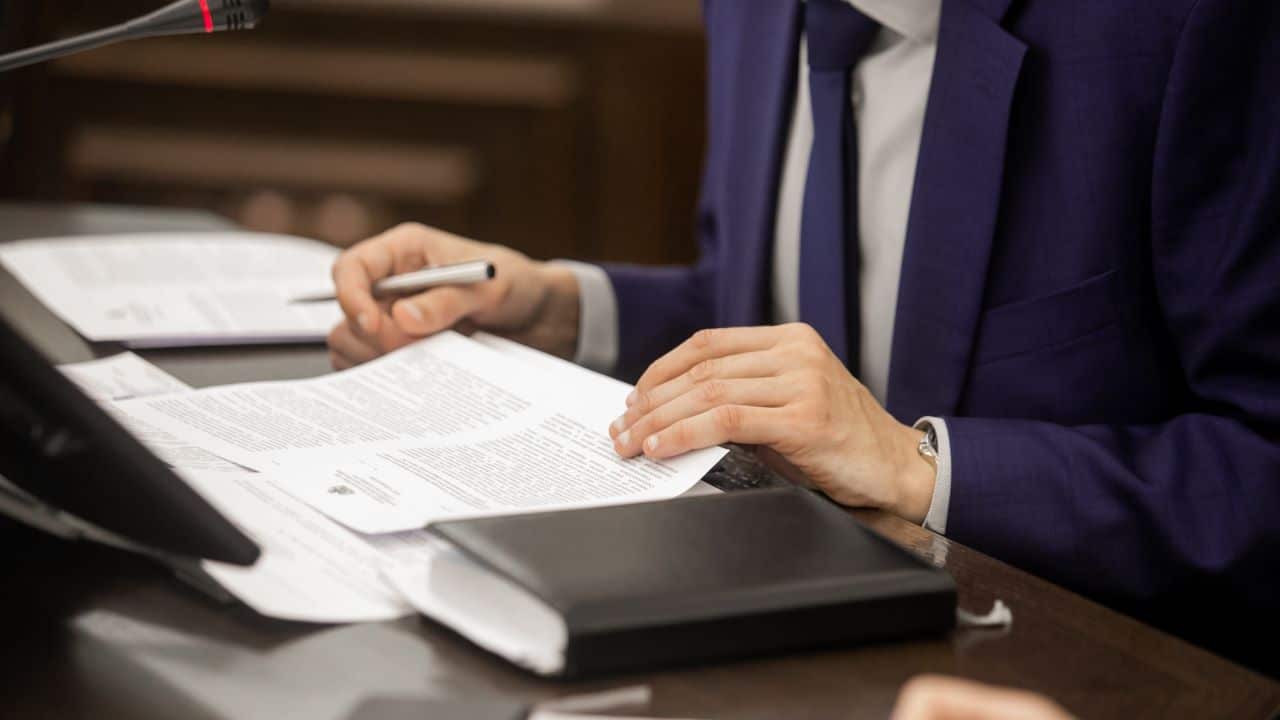 Person in suit signing documents