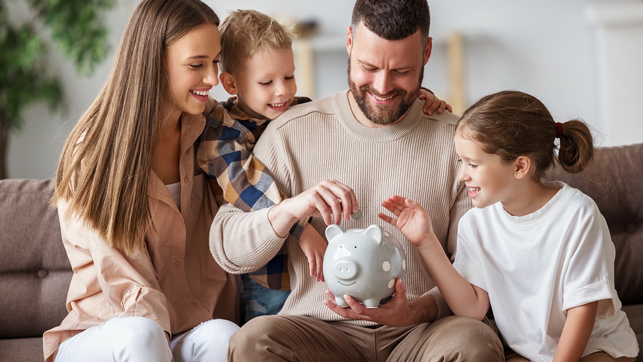 Family adding money to piggy bank